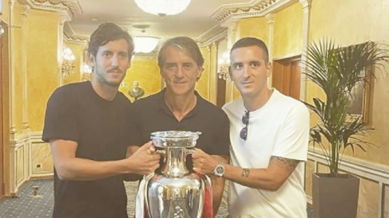 Andrea Mancini (kanan) bersama sang ayah dan kakak sulungnya berfoto bersama trofi Piala Eropa 2020 yang diraih Italia setelah mengalahkan Inggris di final.